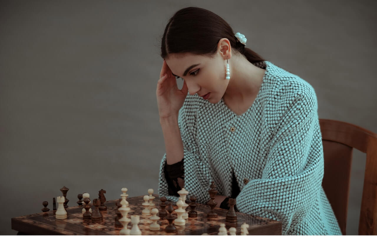 Woman thinking hard about her next strategic chess move