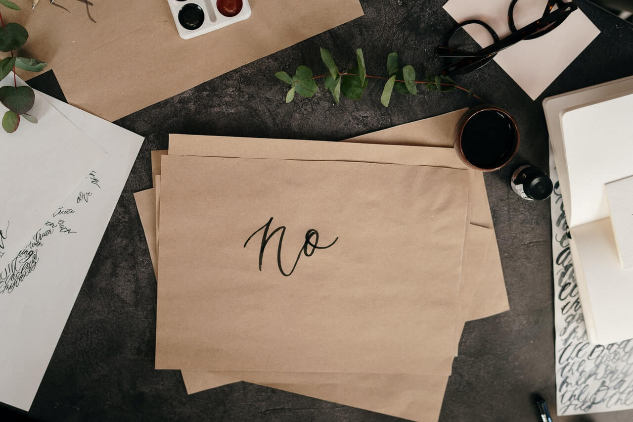 The text "no" handwritten on a brown paper