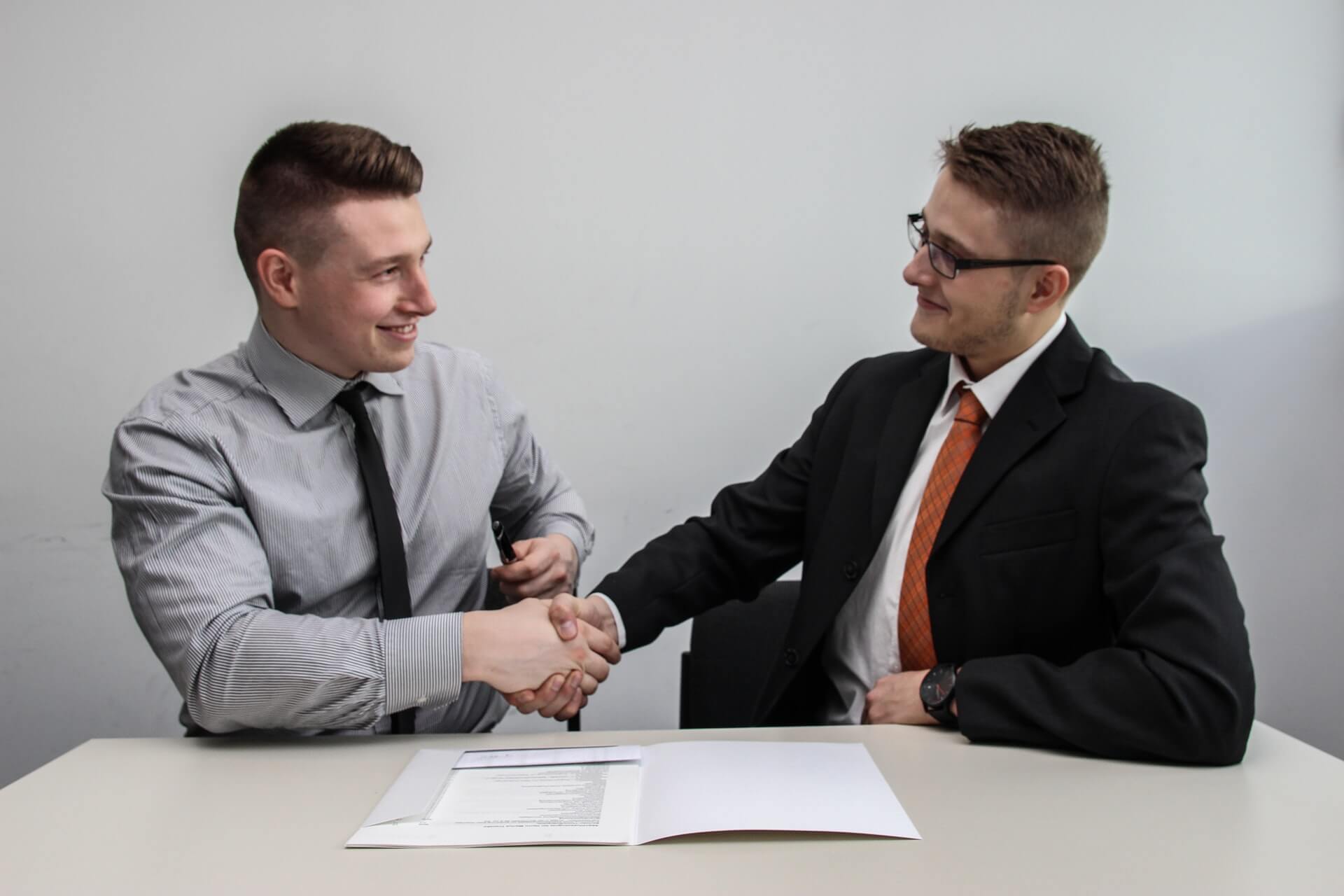 Businessman shaking hands with a client over contract papers