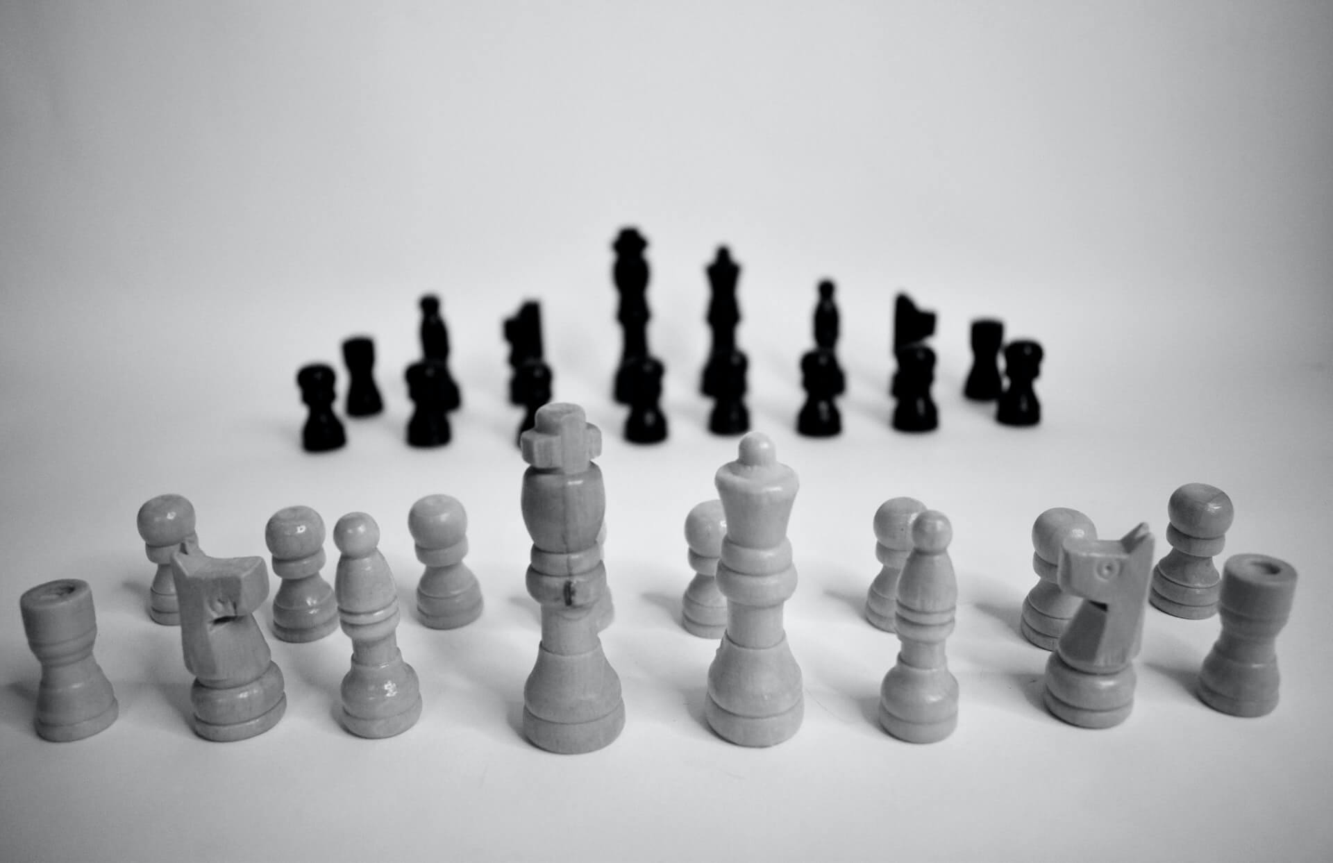 White and black chess pieces on a grey surface