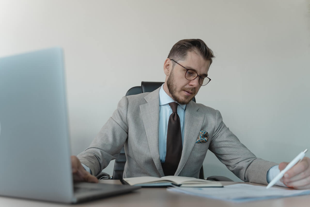 Man in grey suit working on a laptop