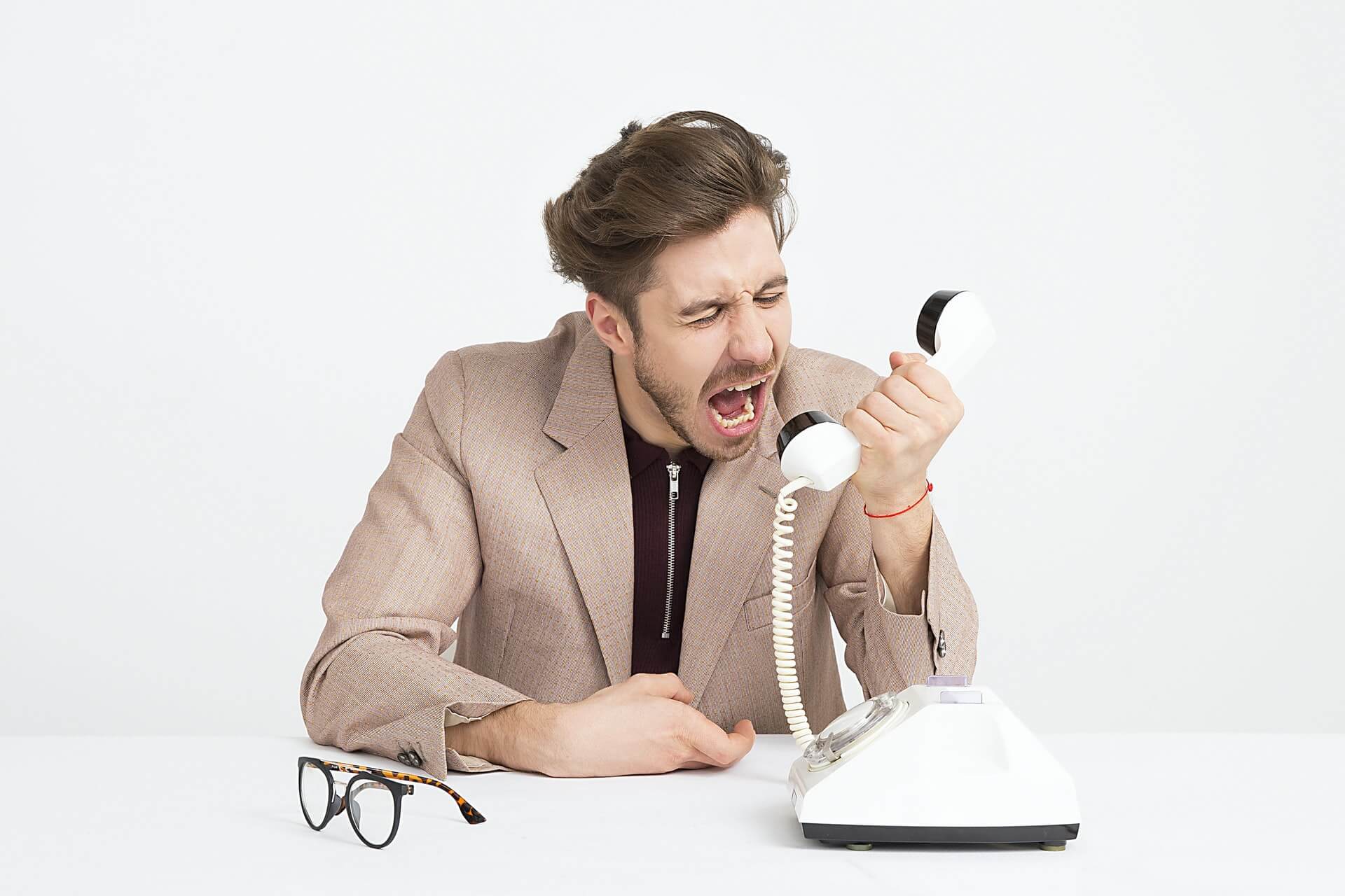 Client support agent screaming angrily at a customer over the phone