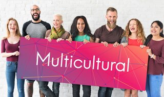 Group of multiracial individuals holding a sign with the word multicultural