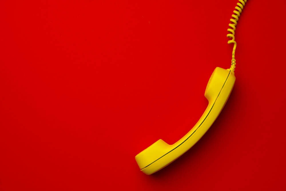 Yellow landline phone on a red background