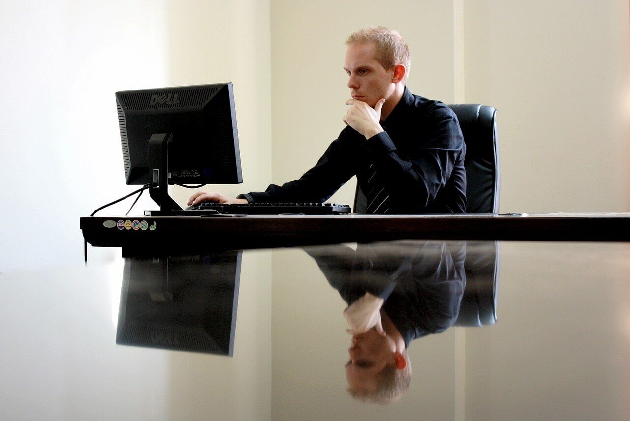 Man wearing suit working with a laptop in an office