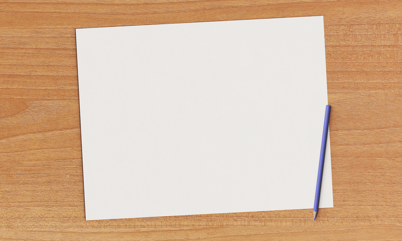 A blank paper on a brown wooden table
