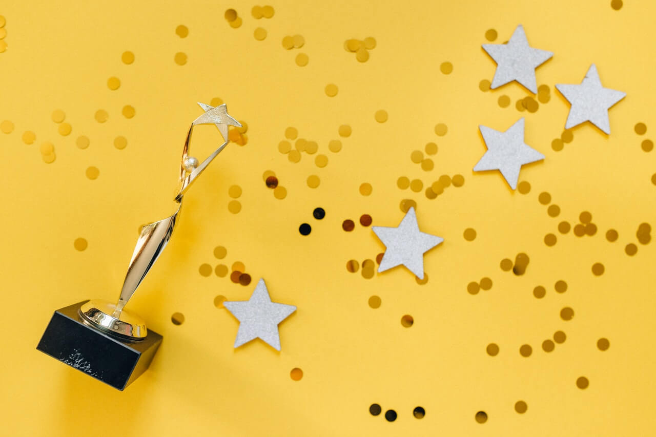 An award and stars on a yellow background