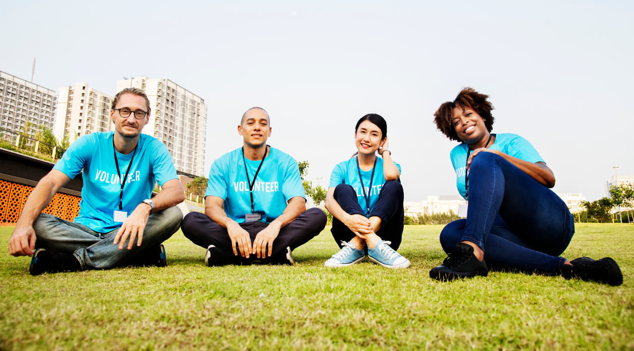 A group of nonprofit volunteers sitting on a field
