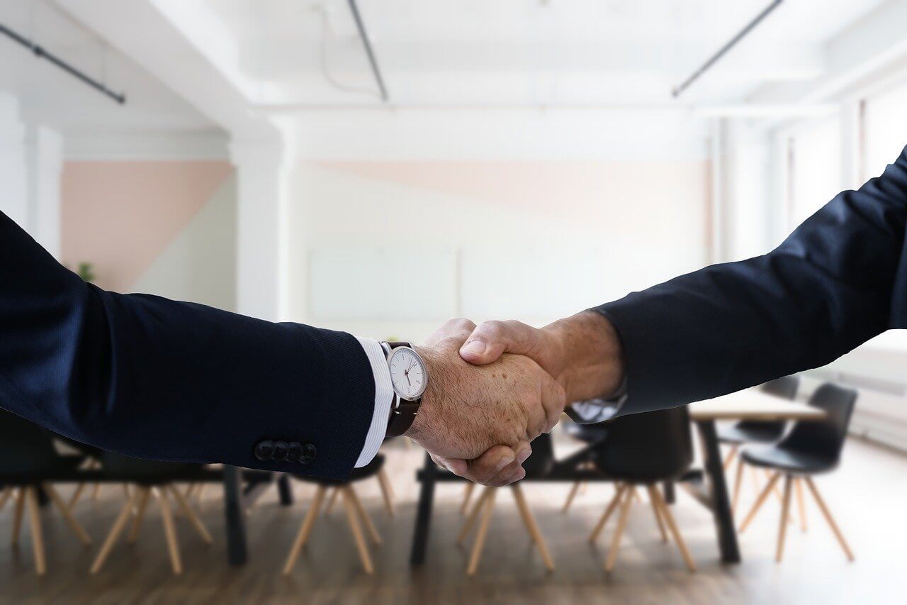 A handshake between two corporate people