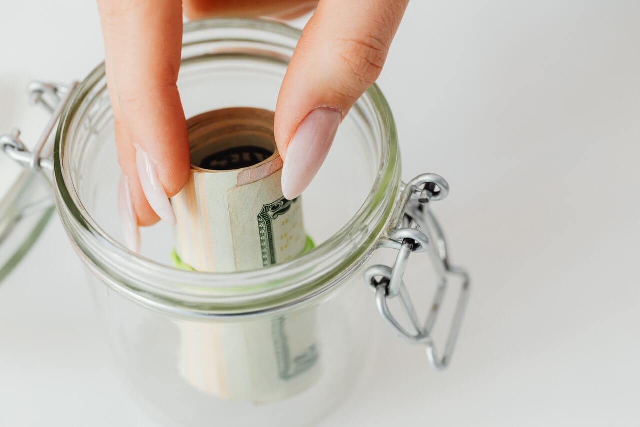 Person putting money in a contribution jar
