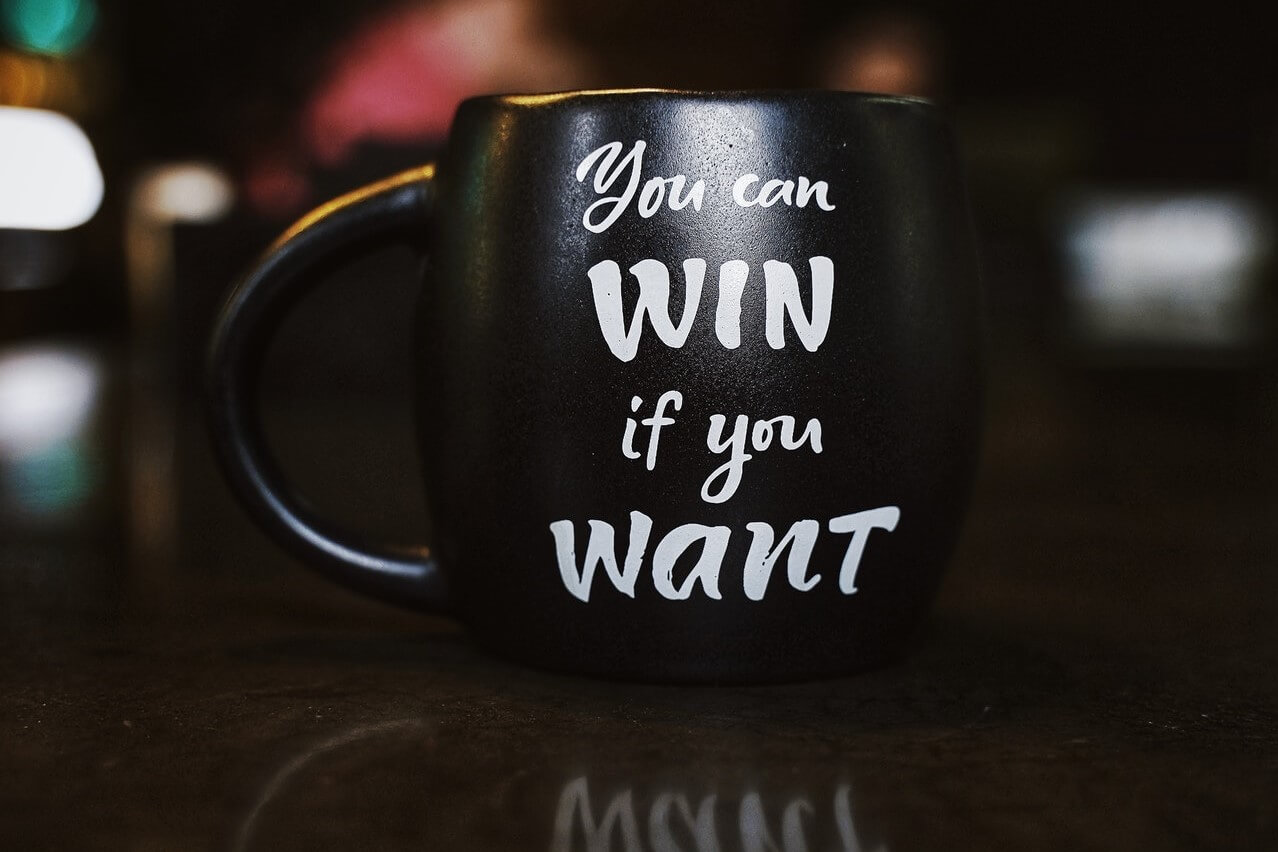 A coffee mug with an inscribed quote on winning