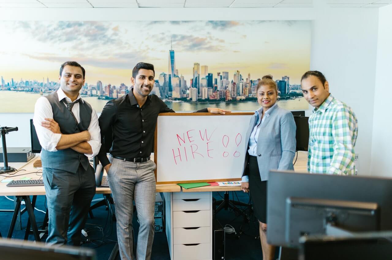 Group-of-people-standing-beside-a-white-board