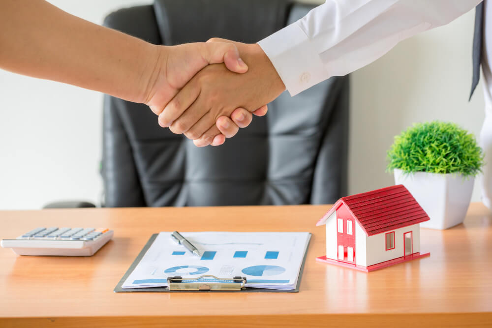 Two businesspeople shaking hands on an investment property deal