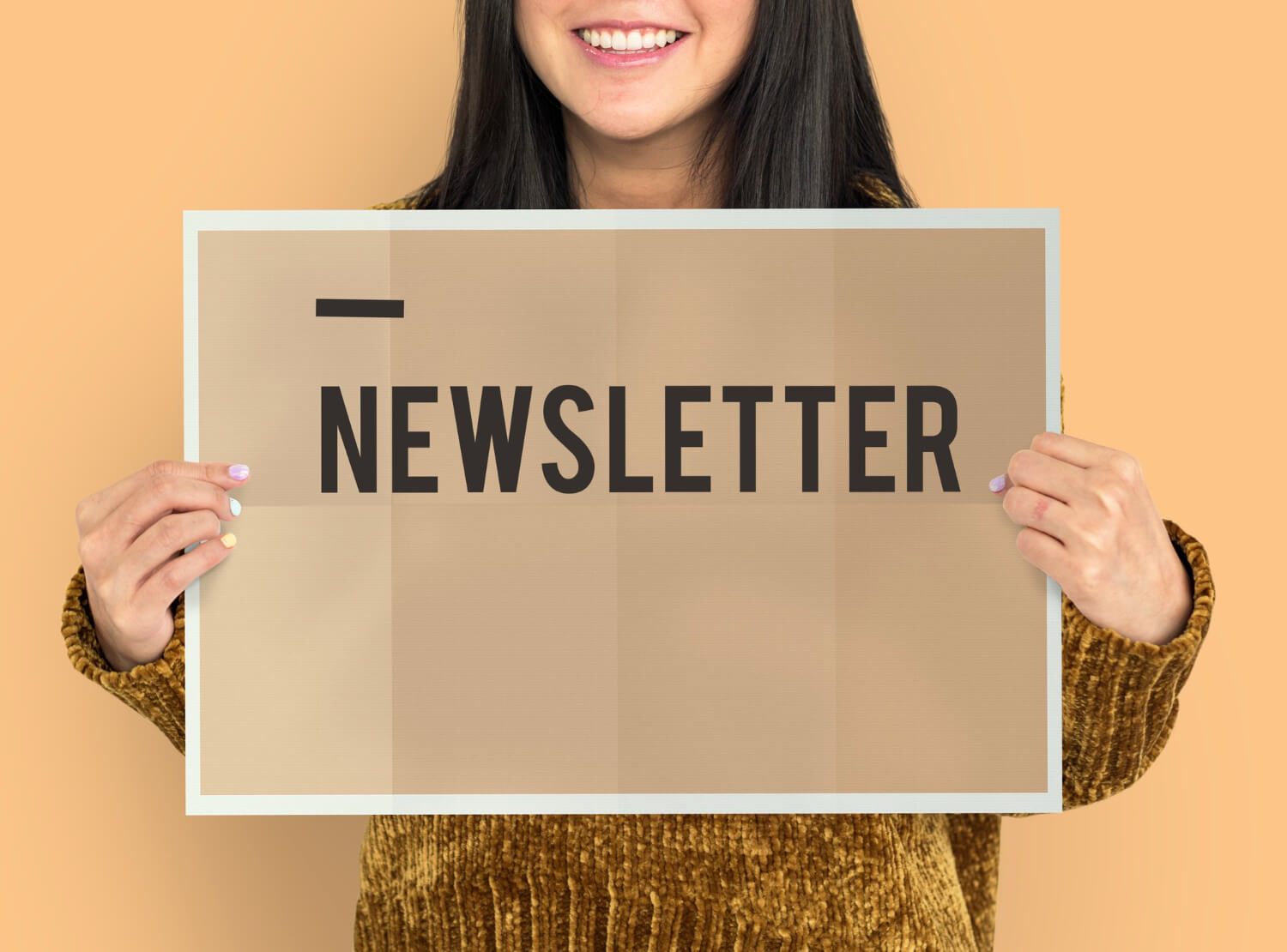 a smiling lady holding a newsletter sign