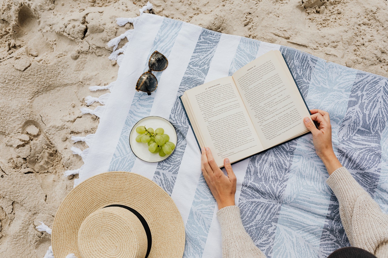 a-person-reading-a-book-in-the-beach