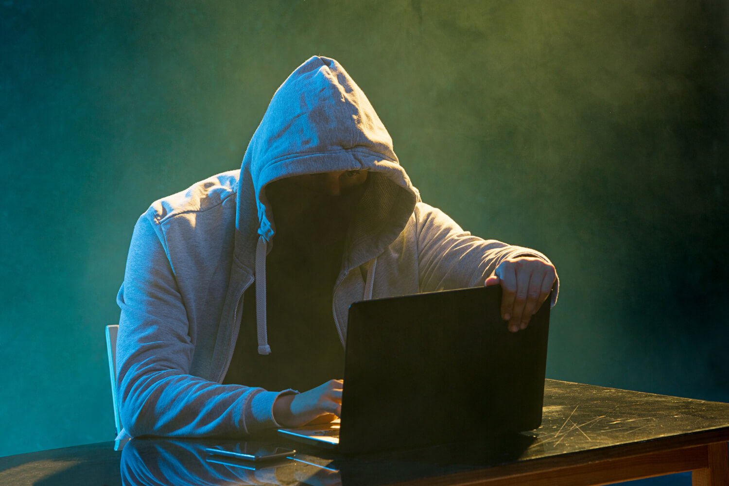 hooded-computer-hacker-stealing-information-with-laptop