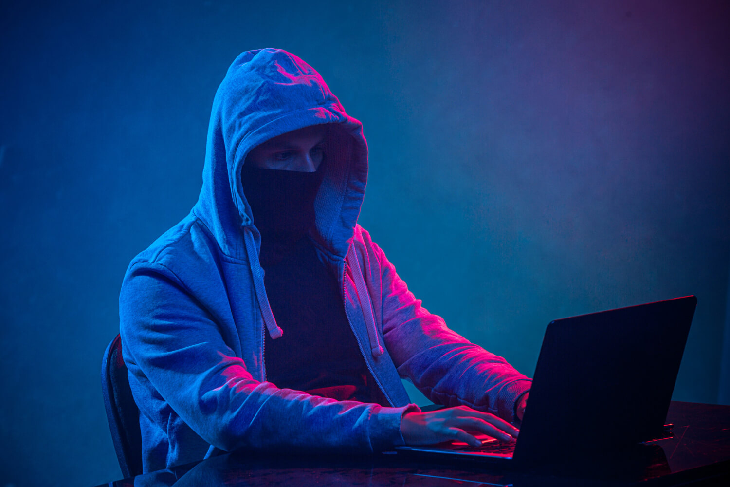 hooded-computer-hacker-stealing-information-with-laptop