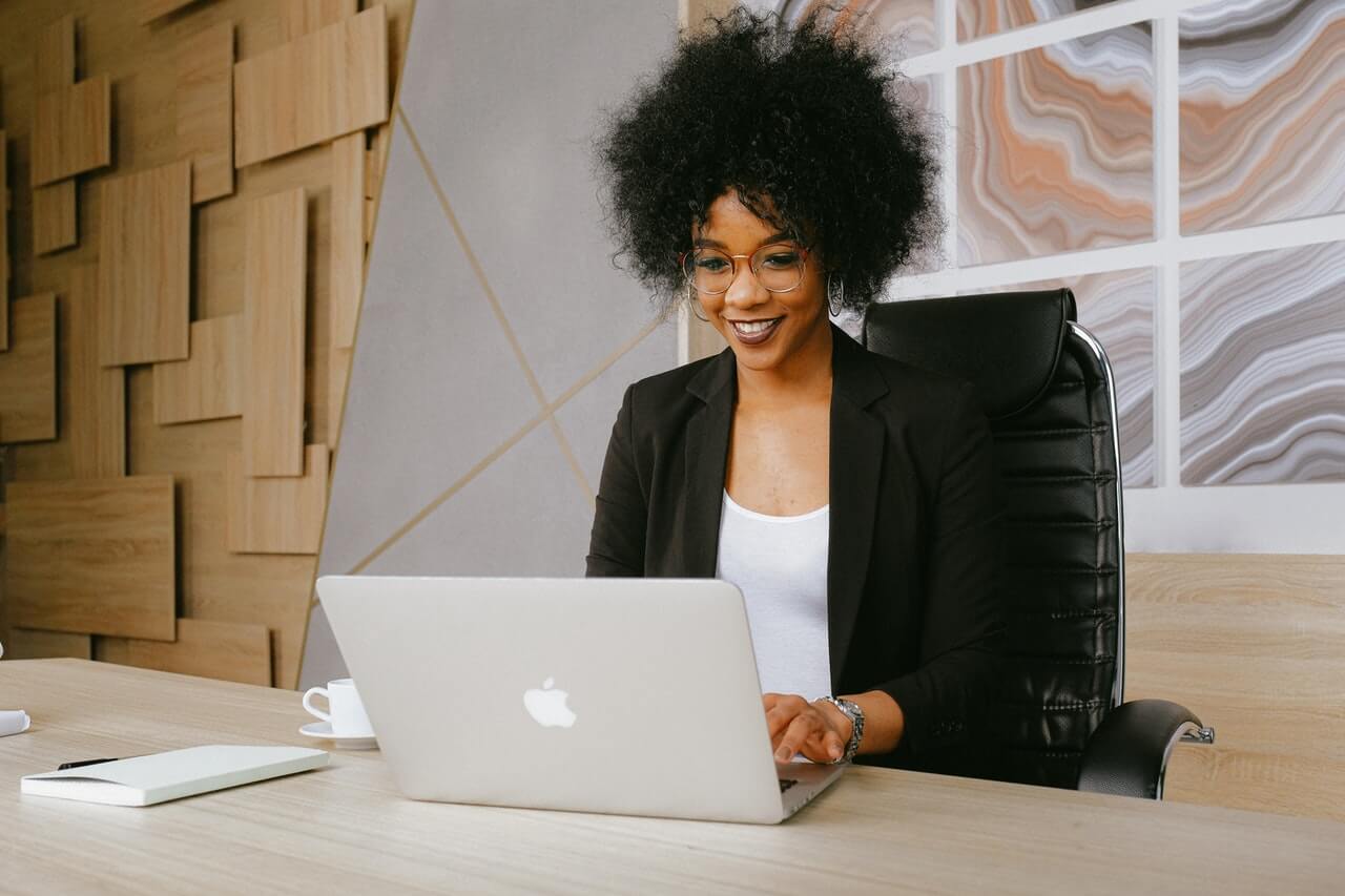 Business woman happily working with a laptop
