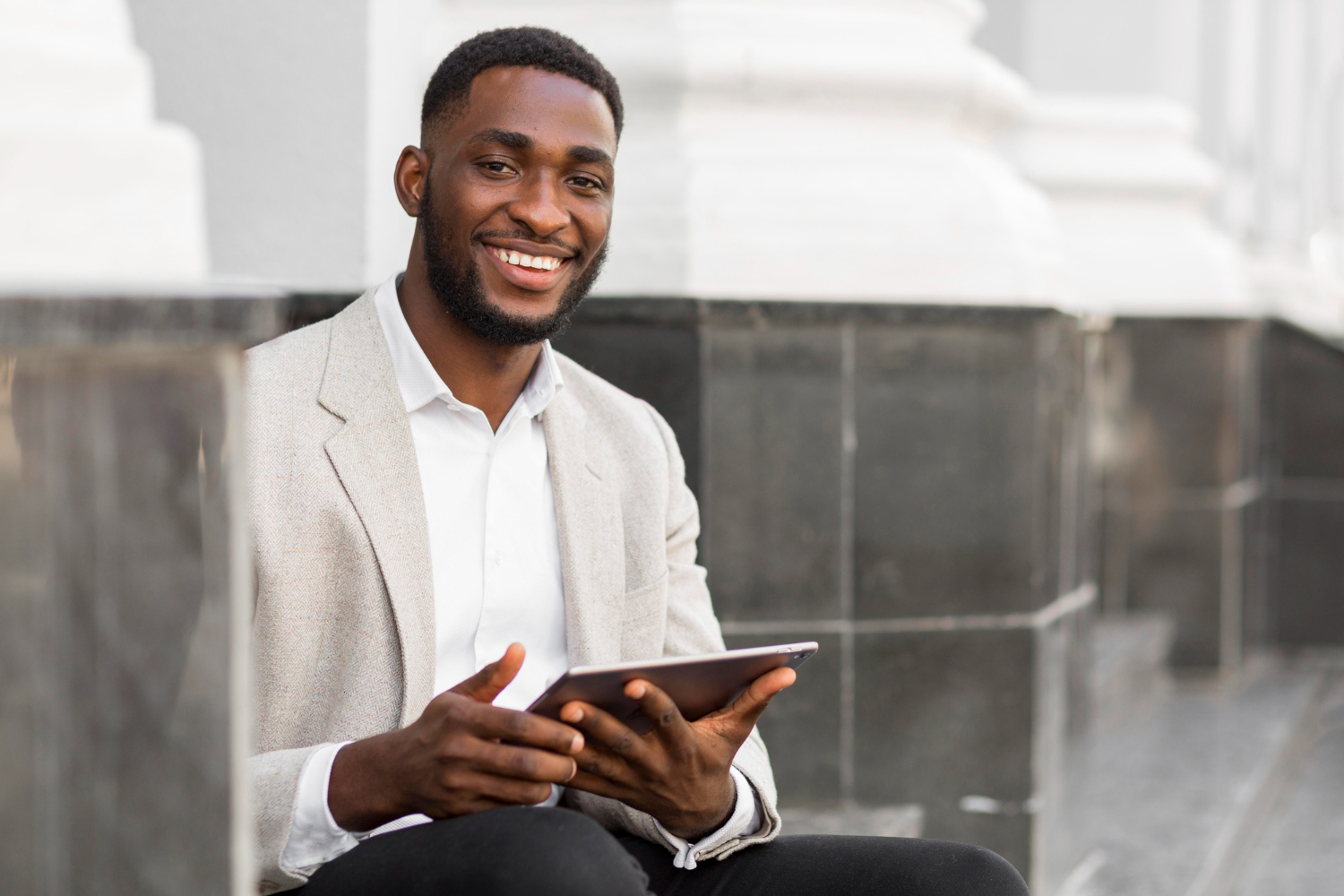 Smiling business man holding a tablet