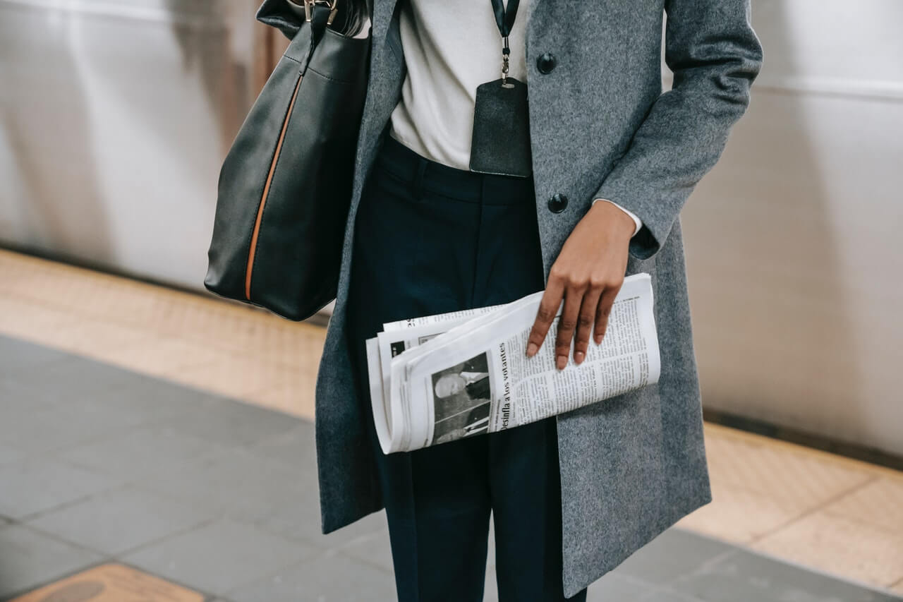 Faceless woman holding a newspaper going to work