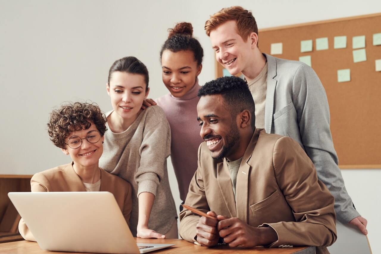 Group of people happily looking a a laptop