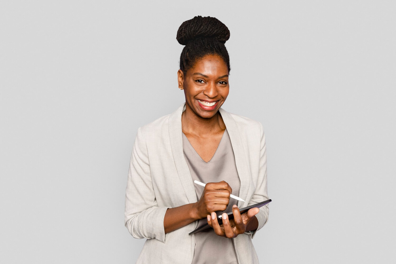 Young woman smiling taking notes on tablet
