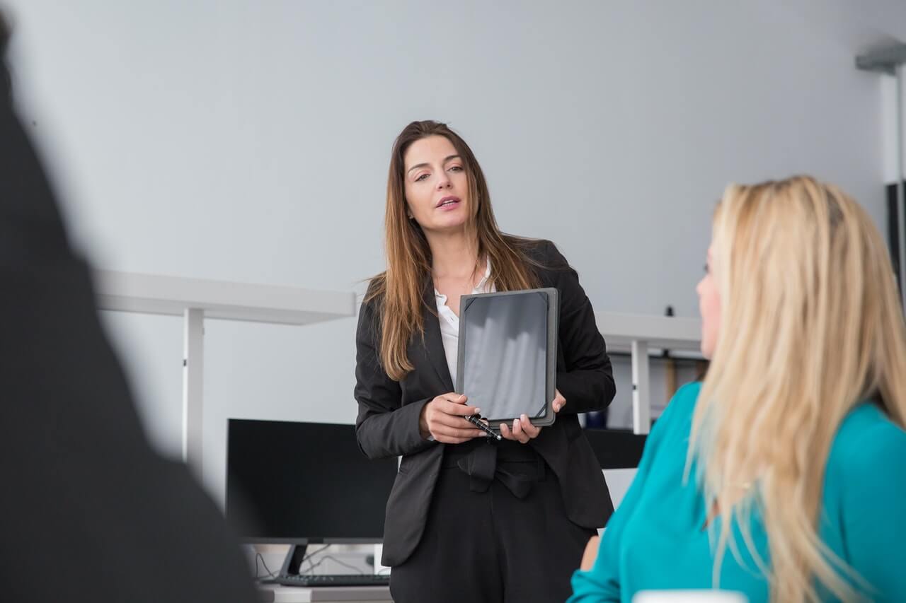 Woman Presenting in a Meeting Using a Tablet