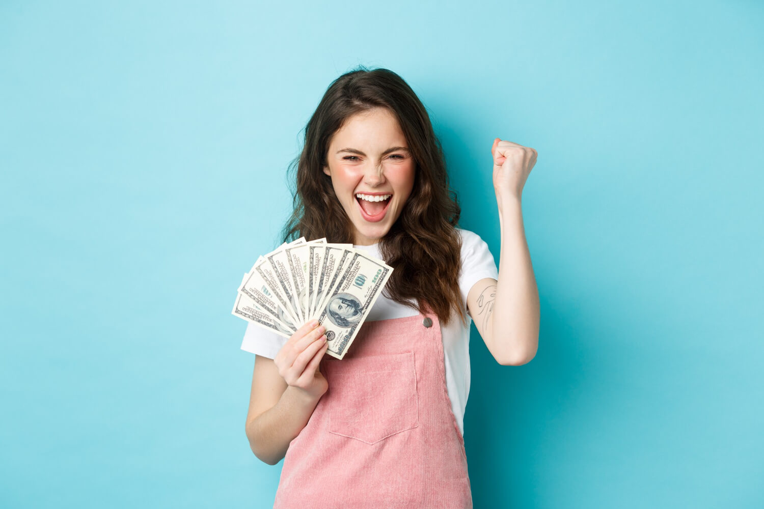 Excited young lady holding dollar bill