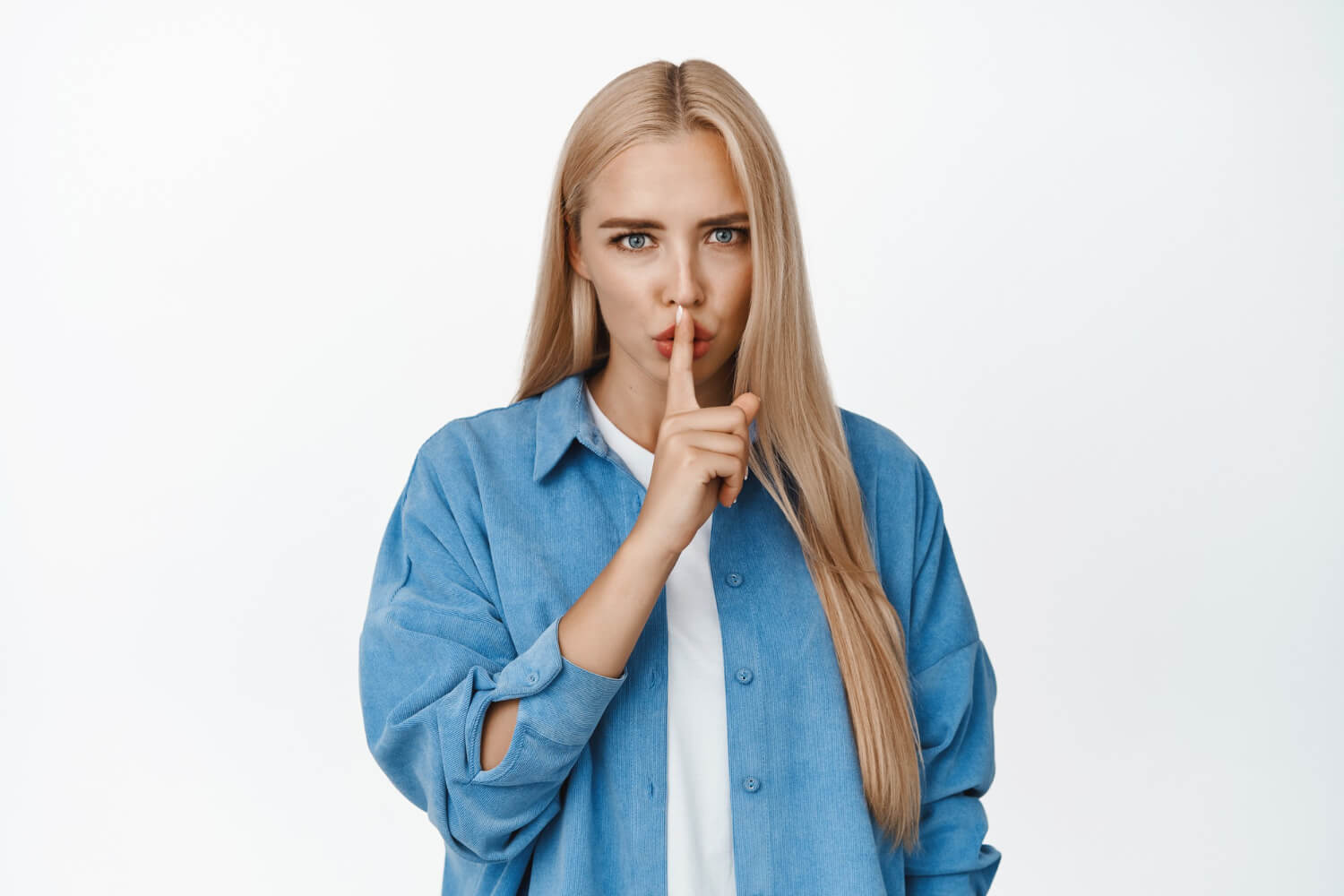 Blond woman making a shhh gesture with her hand on her lips