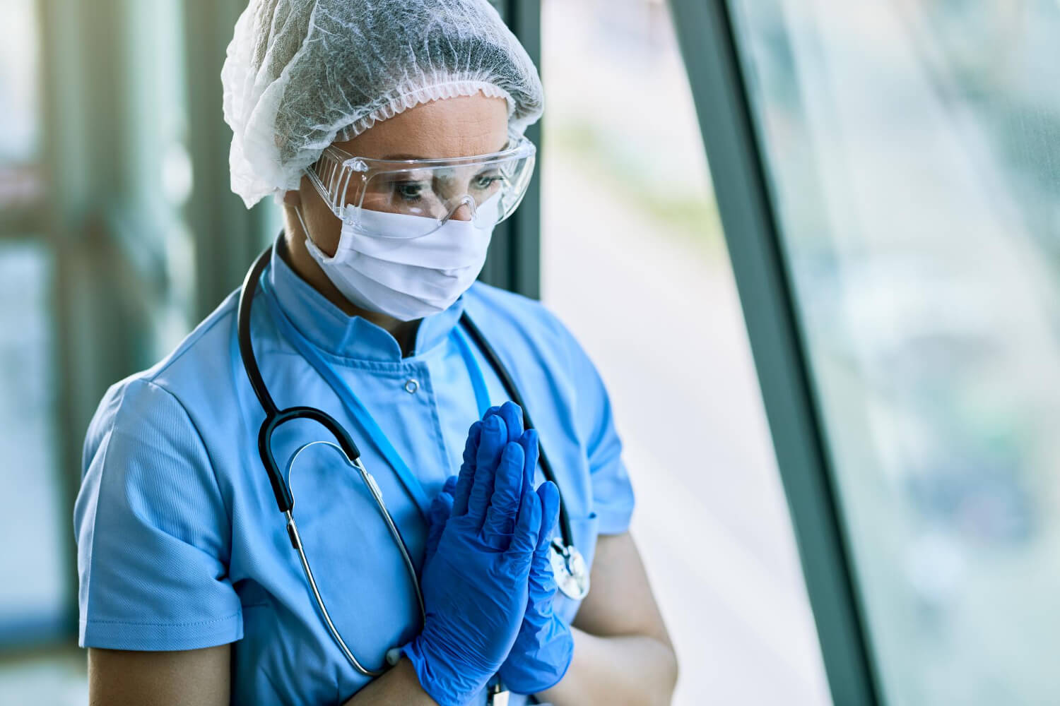 healthcare-worker-praying-with-hands-clasped-while-working-hospital.j