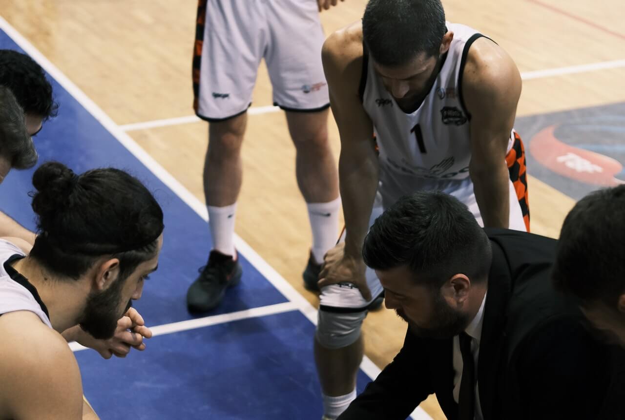 A-basketball-coach-reviewing-tactics-with-players