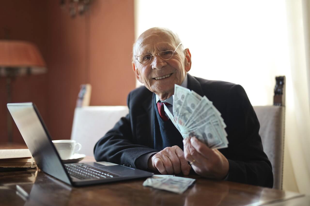 A businessman holding money while working in his office