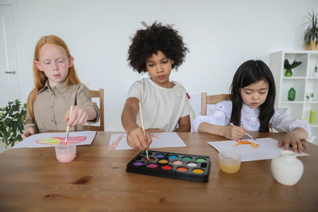 Diverse children drawing and painting together