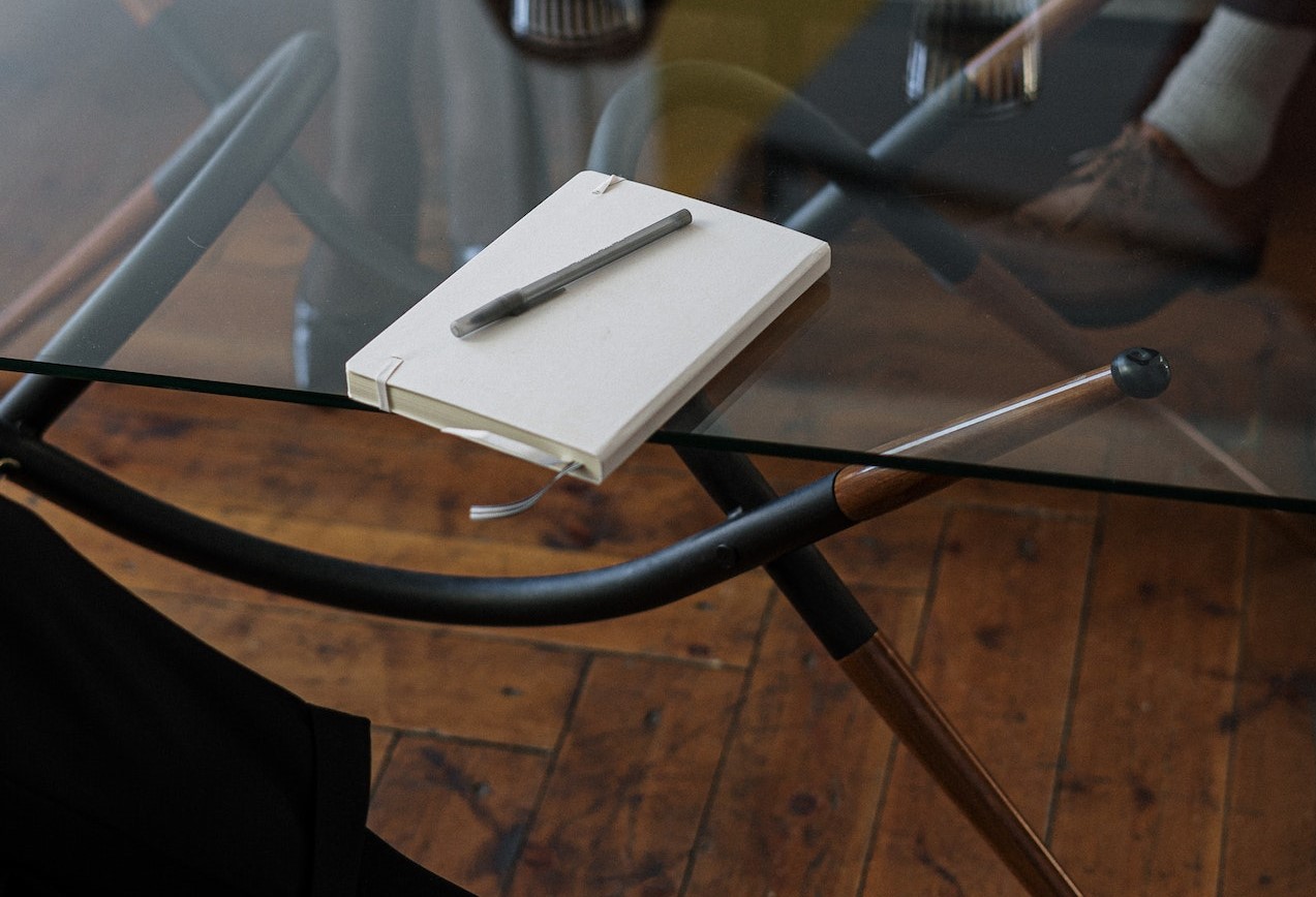 Book and pen on a glass table