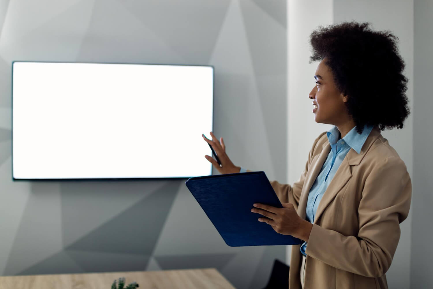 Business woman presenting with projection screen in an office