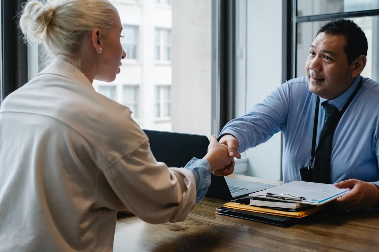 businessman shaking hand of applicant in office