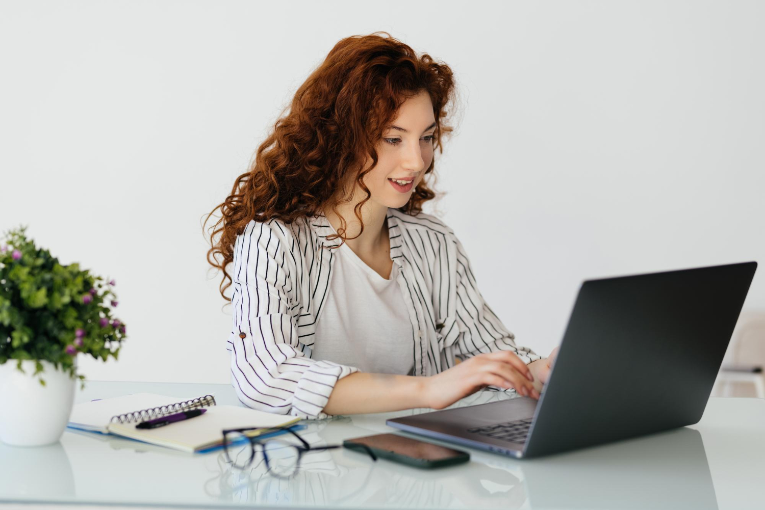 Woman-typing-on a laptop-while-sitting-at a desk