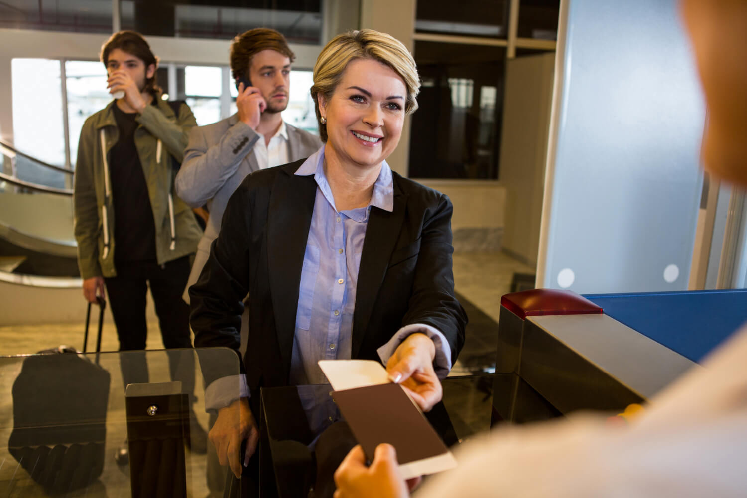businesswoman-handing-her-boarding-pass-female-staff