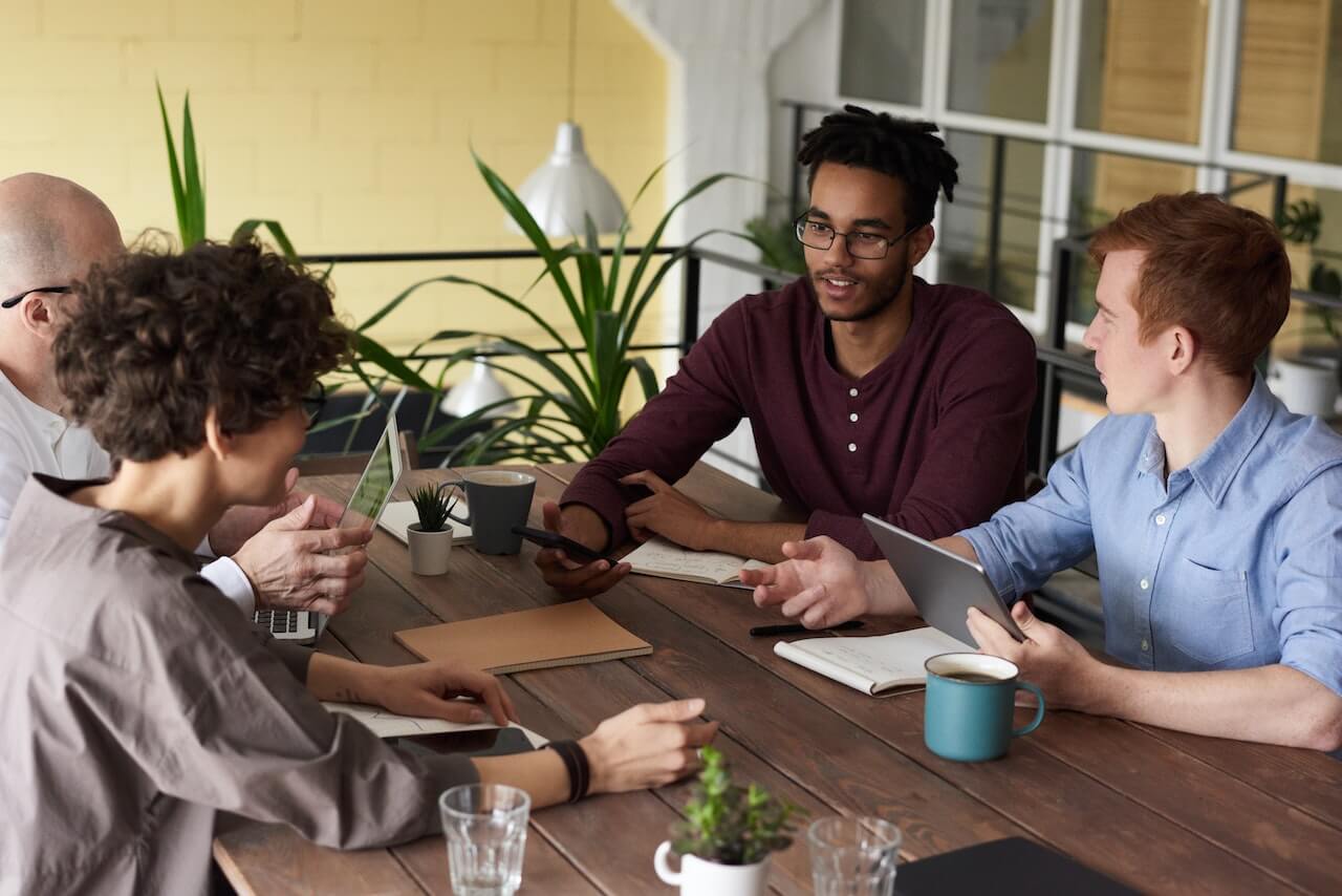 People Leaning On Wooden Table While Having a Business Meeting