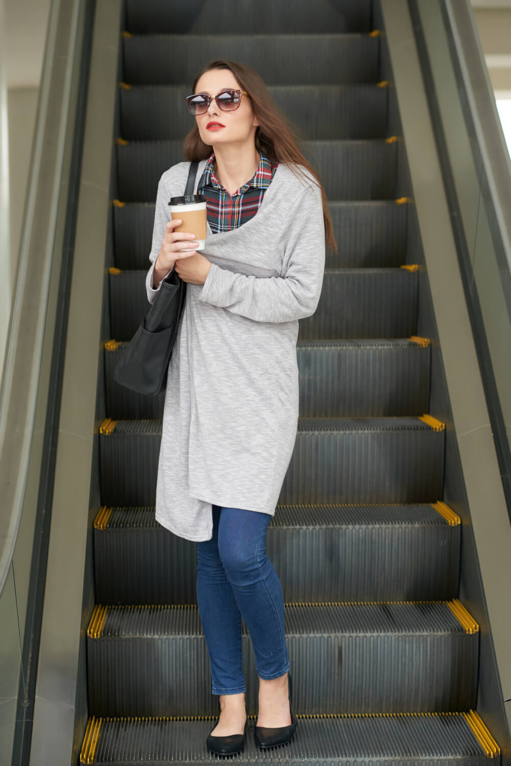 A woman using an escalator to go down