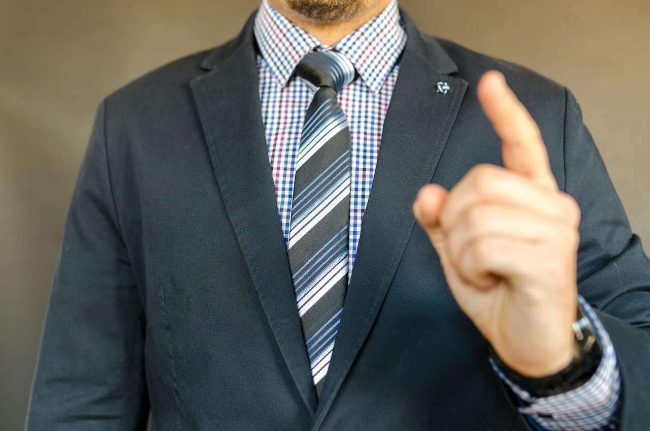 Man in suit holding up a finger
