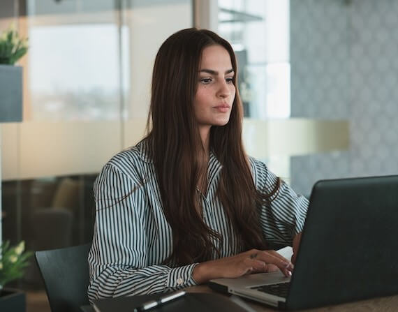 Portrait of Brown Haired Woman Working on Laptop in Office