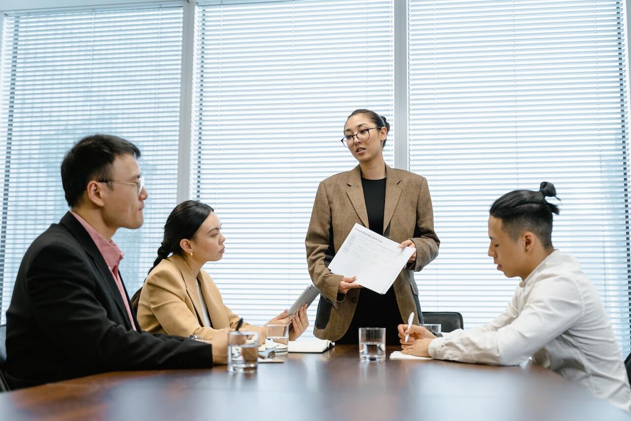 Woman standing up asking questions during meeting