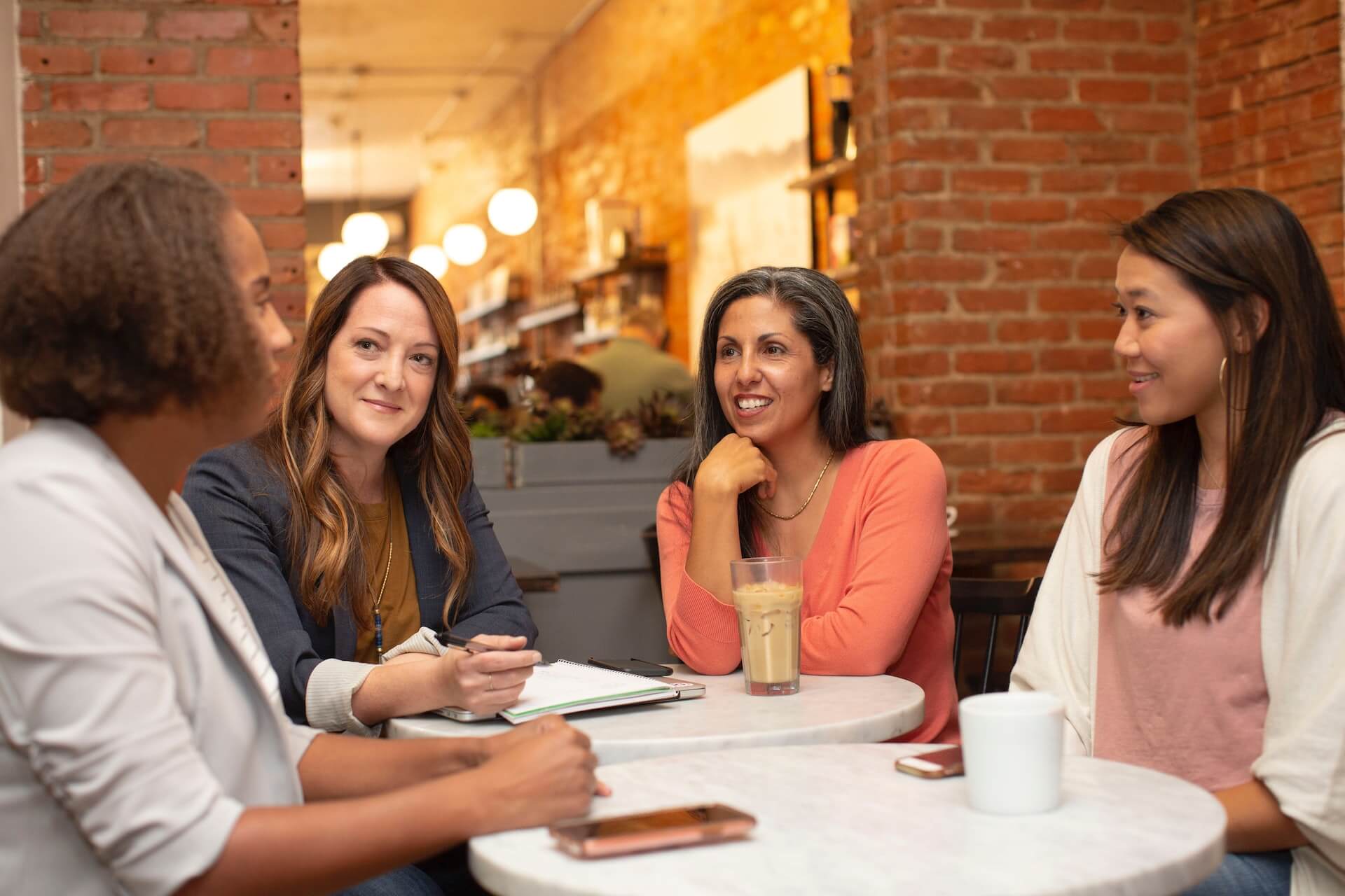 Four women working in a business meeting in a coffee shop