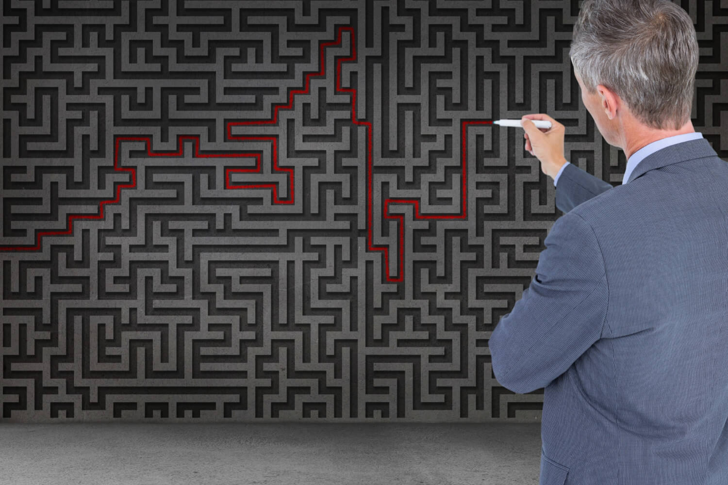 a-businessman-solving-maze-on-a-wall
