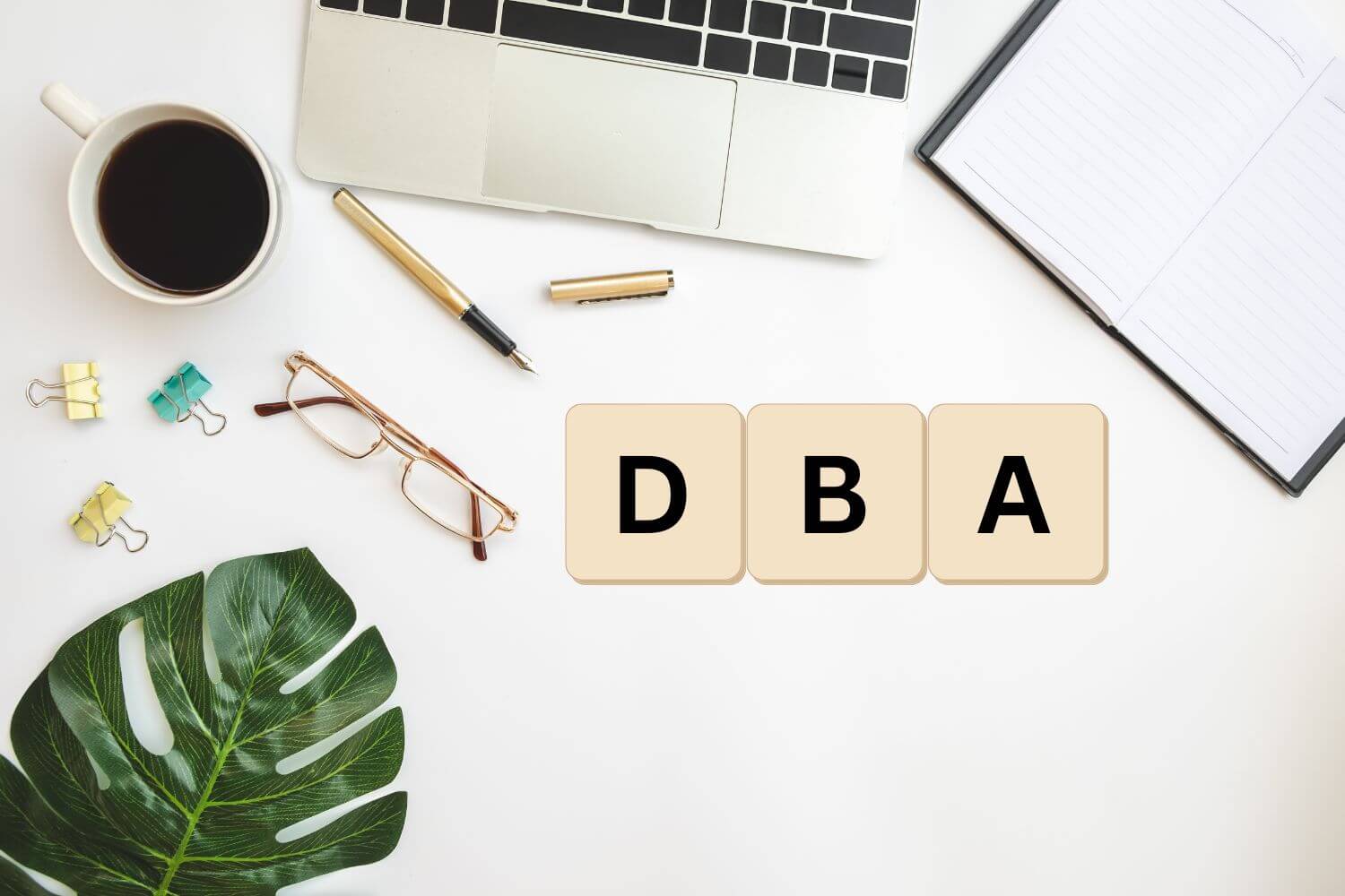 Scrabble tiles spelling "DBA" on an office desk