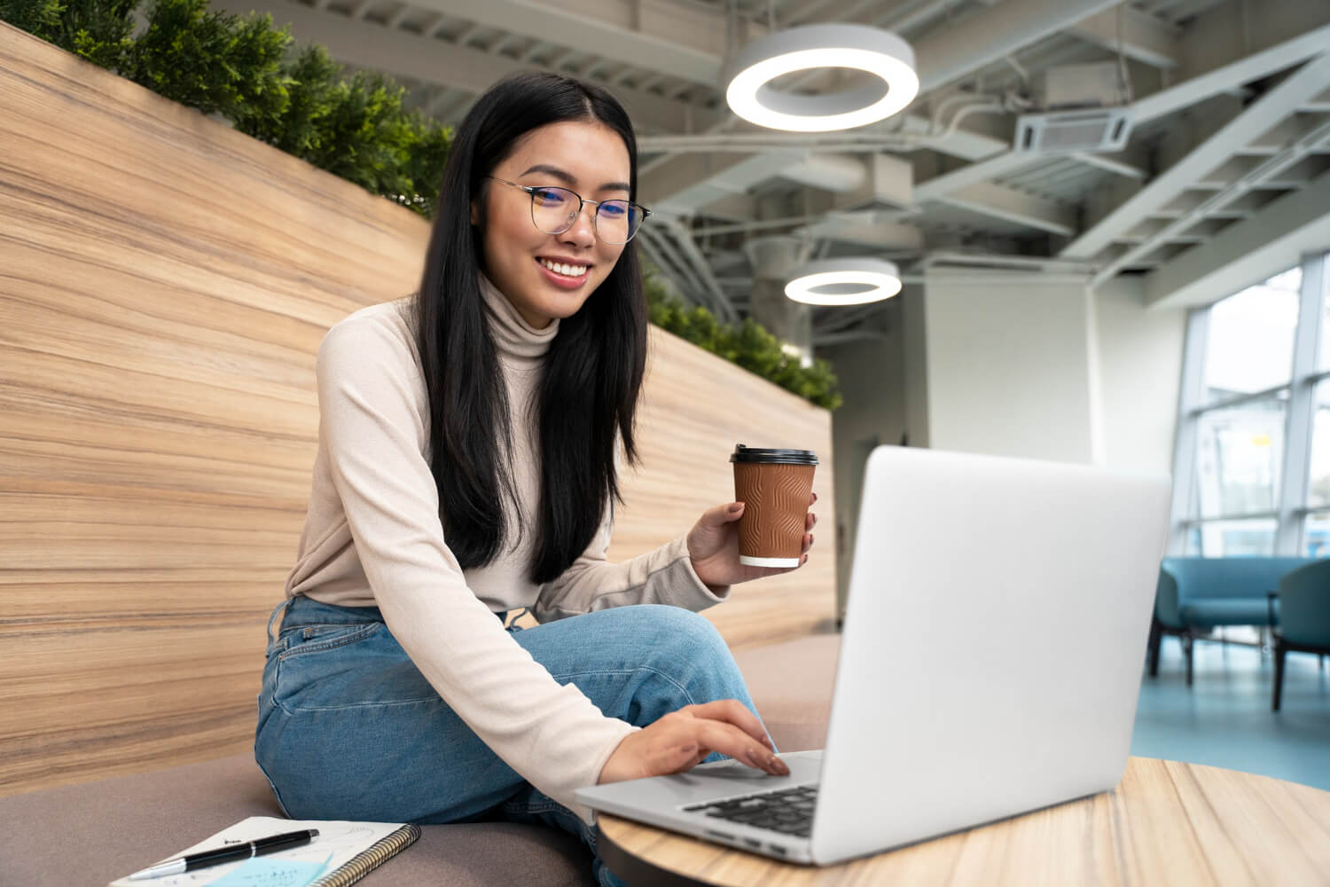 Young woman with a cup of coffee working on her laptop